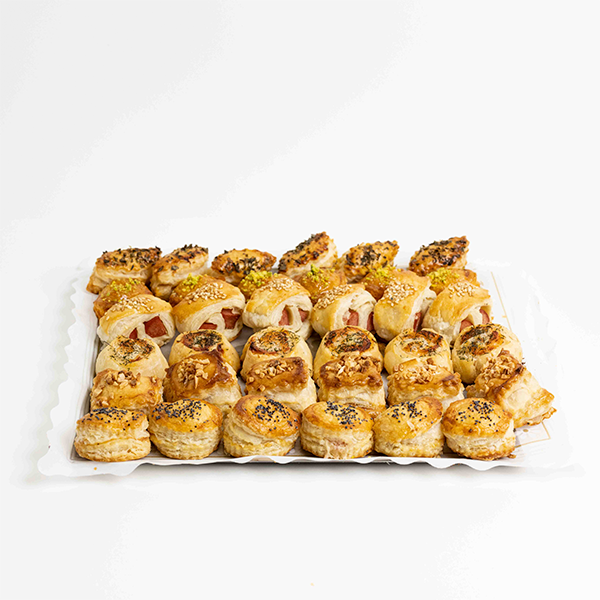 Hojaldritos salados variados de Formentor, con rellenos como jamón y queso, sobrasada, salchicha y salmón, presentados sobre fondo blanco.